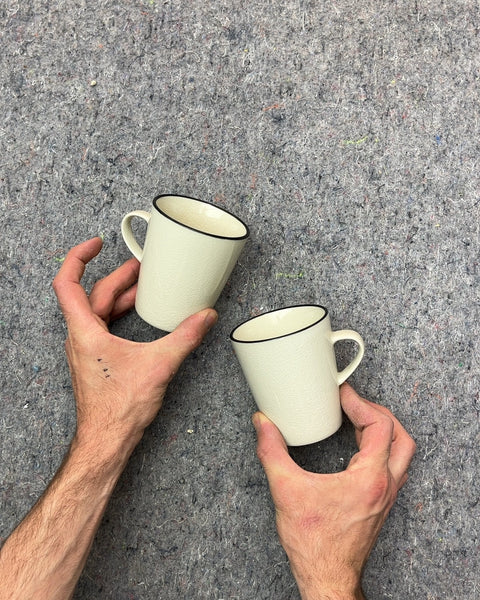 Two Pretty Crate & Barrel Cream Textured Mugs with Black Rim