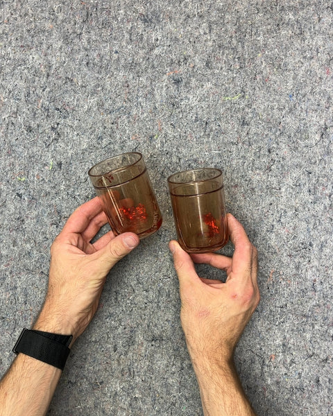 Two Plastic Cups With Confetti Floating In Water Around Them