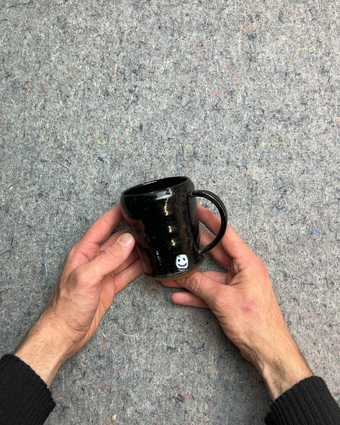 Black Ceramic Mug with White Smiley Face On One Side And Sad Face On The Other