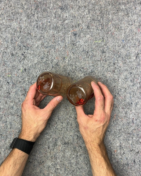 Two Plastic Cups With Confetti Floating In Water Around Them