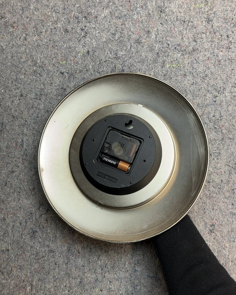 Round Silver Wall Clock With A Light Scratches At The Bottom