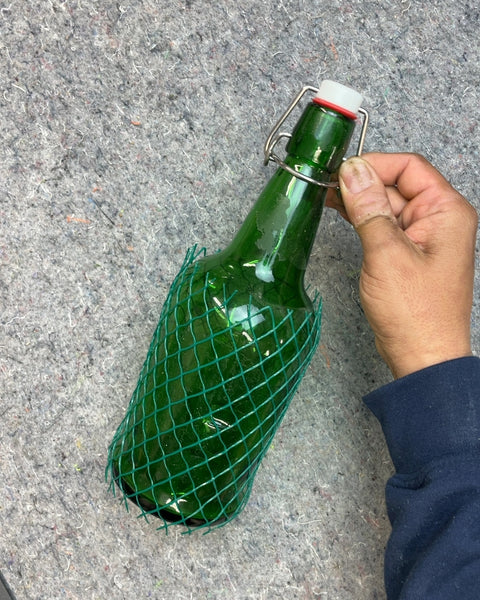 Green Glass Bottle with Swing Top and Protective Netting
