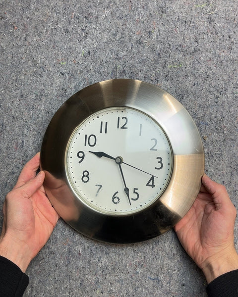 Round Silver Wall Clock With A Light Scratches At The Bottom