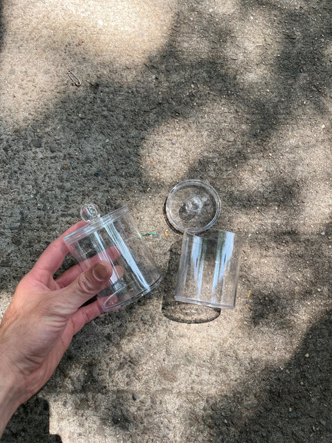 A Medium And A Small Clear Plastic Storage Jars
