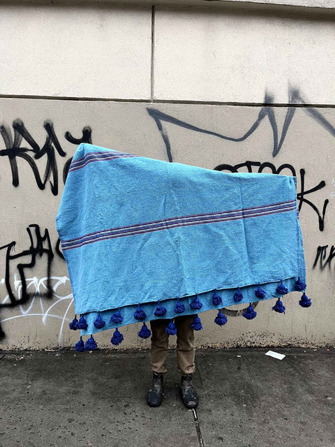 A Pretty Blue Pom Pom Throw Blanket