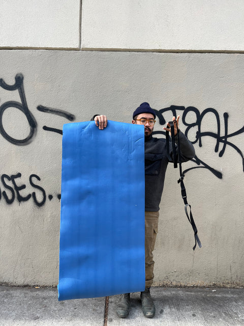 A Foamy Yoga Mat With A Strap To Carry It